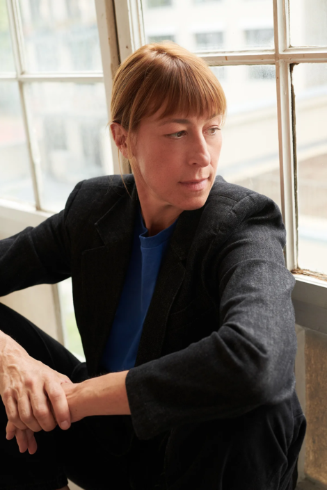 Helene Grass im Halbportrait, aus dem Fenster schauend